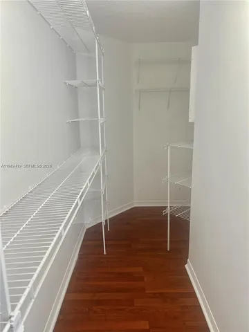 a view of a room with wooden floor and white walls