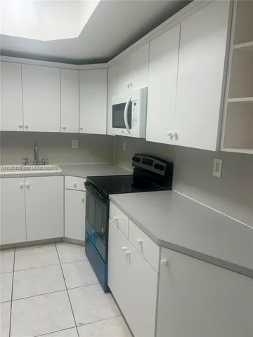a kitchen with a cabinets and white appliances