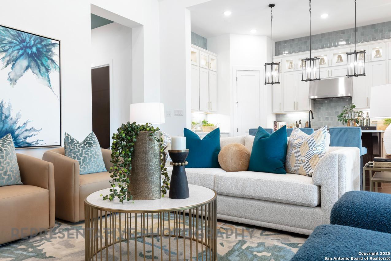 235 Boulder Creek Boerne, TX 78006 - Photo 12 of 40 a living room with furniture kitchen view and a chandelier