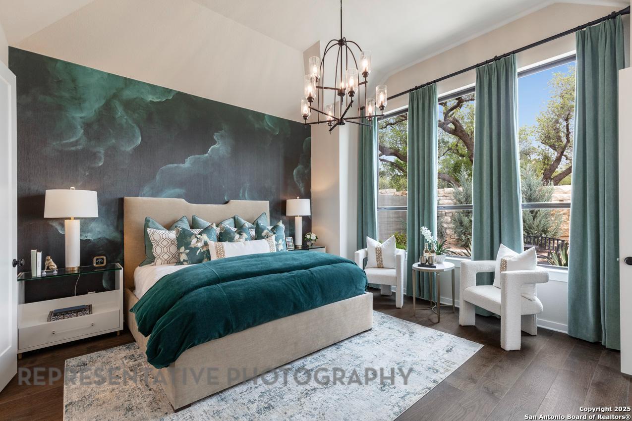 235 Boulder Creek Boerne, TX 78006 - Photo 14 of 40 a bedroom with a large bed and a chandelier