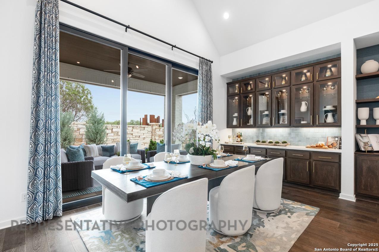 235 Boulder Creek Boerne, TX 78006 - Photo 25 of 40 a kitchen with a stove a sink and white cabinets with wooden floor