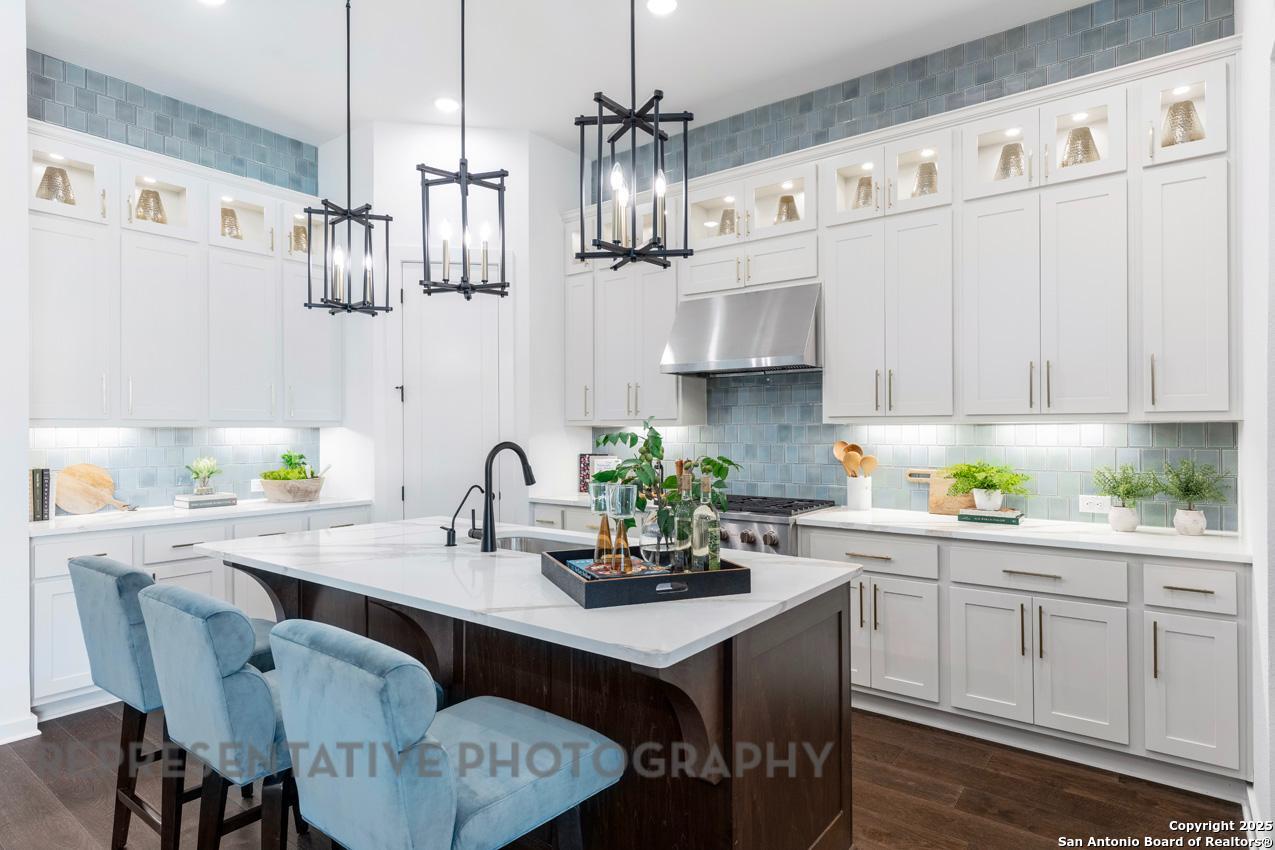 235 Boulder Creek Boerne, TX 78006 - Photo 6 of 40 a kitchen with stainless steel appliances a white table chairs and a cabinets