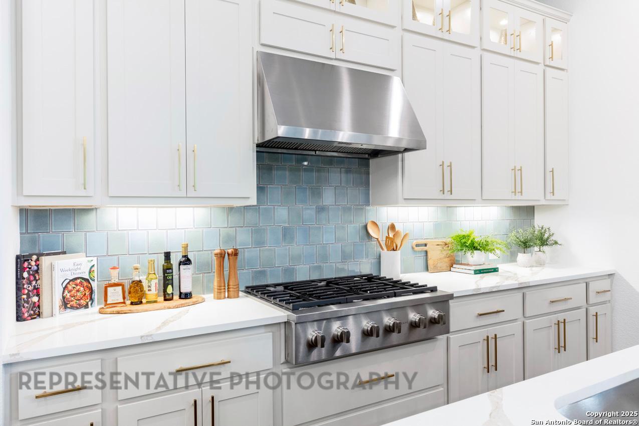 235 Boulder Creek Boerne, TX 78006 - Photo 7 of 40 a kitchen with stainless steel appliances granite countertop a stove a sink and a white cabinets