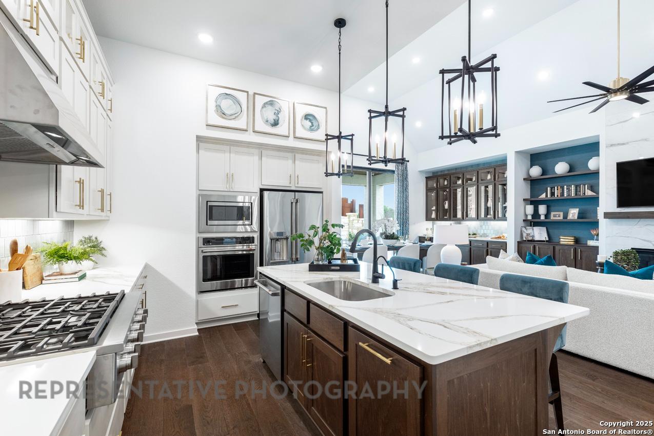 235 Boulder Creek Boerne, TX 78006 - Photo 9 of 40 a kitchen with stainless steel appliances kitchen island a large island in the center and cabinets