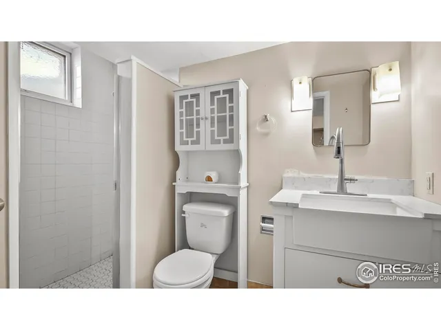 a bathroom with a toilet a sink and mirror