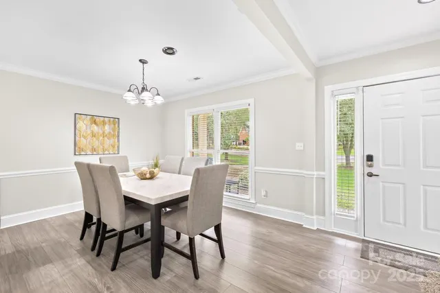 a dining room with furniture a chandelier and wooden floor