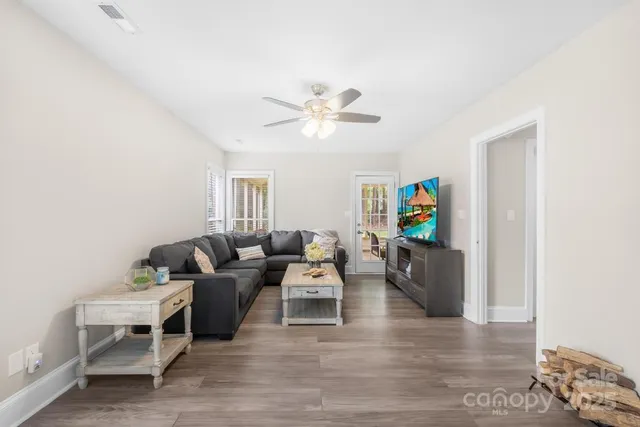 a living room with furniture and a wooden floor