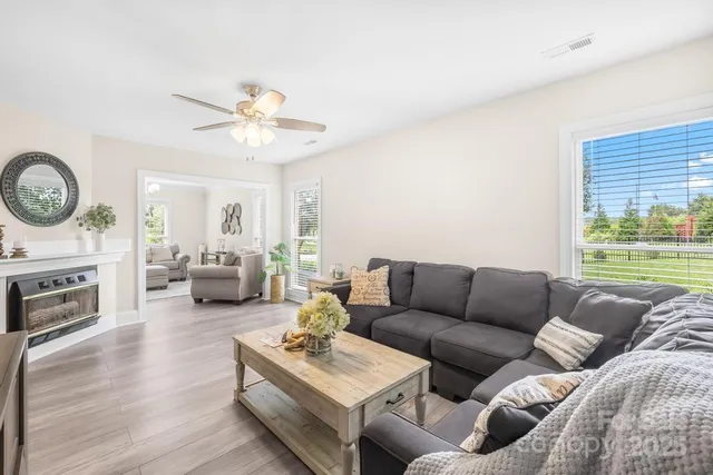 a living room with furniture a fireplace and a window