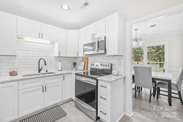 a kitchen with stainless steel appliances granite countertop a sink stove and cabinets