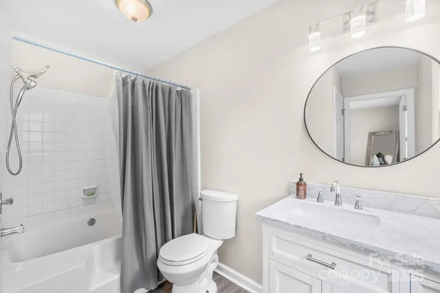 a bathroom with a granite countertop sink toilet a mirror and shower