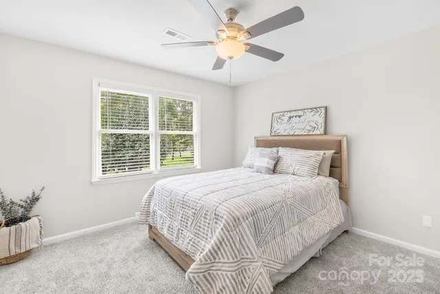 a bedroom with a bed chandelier and a window