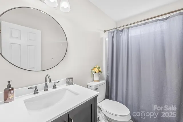 a bathroom with a sink a toilet and a mirror