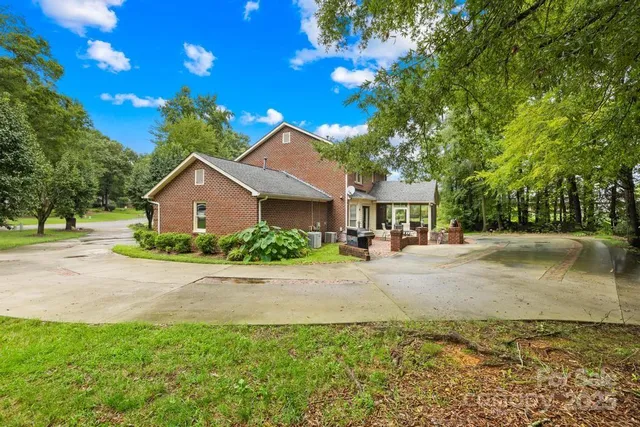 a front view of a house with yard and parking