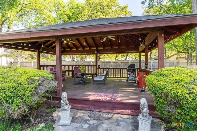 a view of a patio with table and chairs potted plants and floor to ceiling window