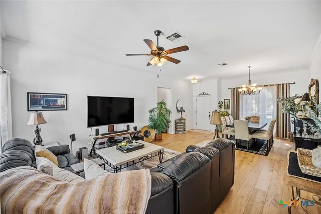 a dining room with furniture a chandelier and wooden floor
