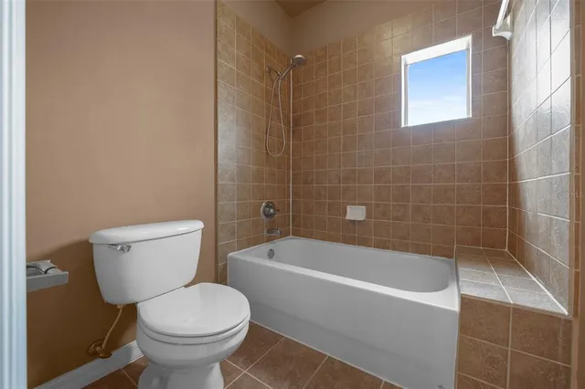 a white toilet sitting next to a bath tub
