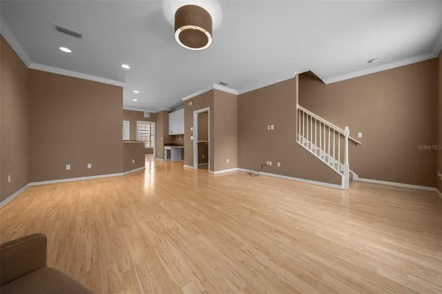 a view of an empty room with wooden floor