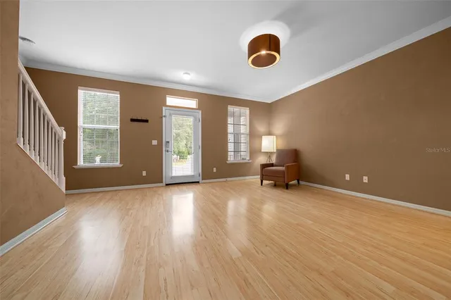 a view of a livingroom with wooden floor and a large window