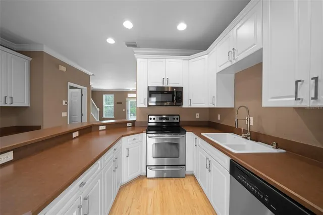 a kitchen with a sink a stove and cabinets