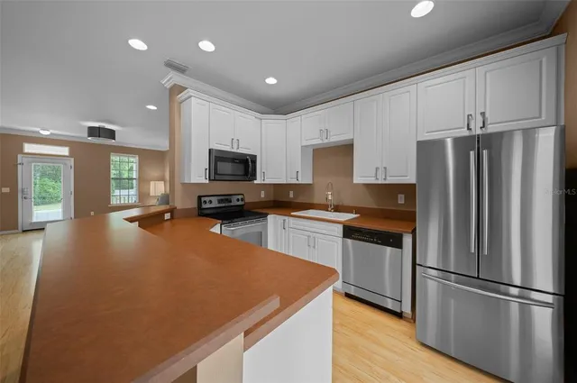 a kitchen with stainless steel appliances a refrigerator sink and microwave