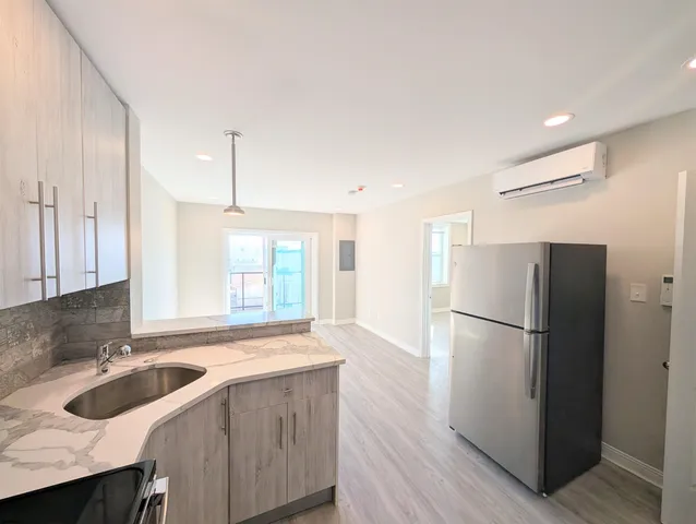a kitchen with a refrigerator a sink and wooden floor