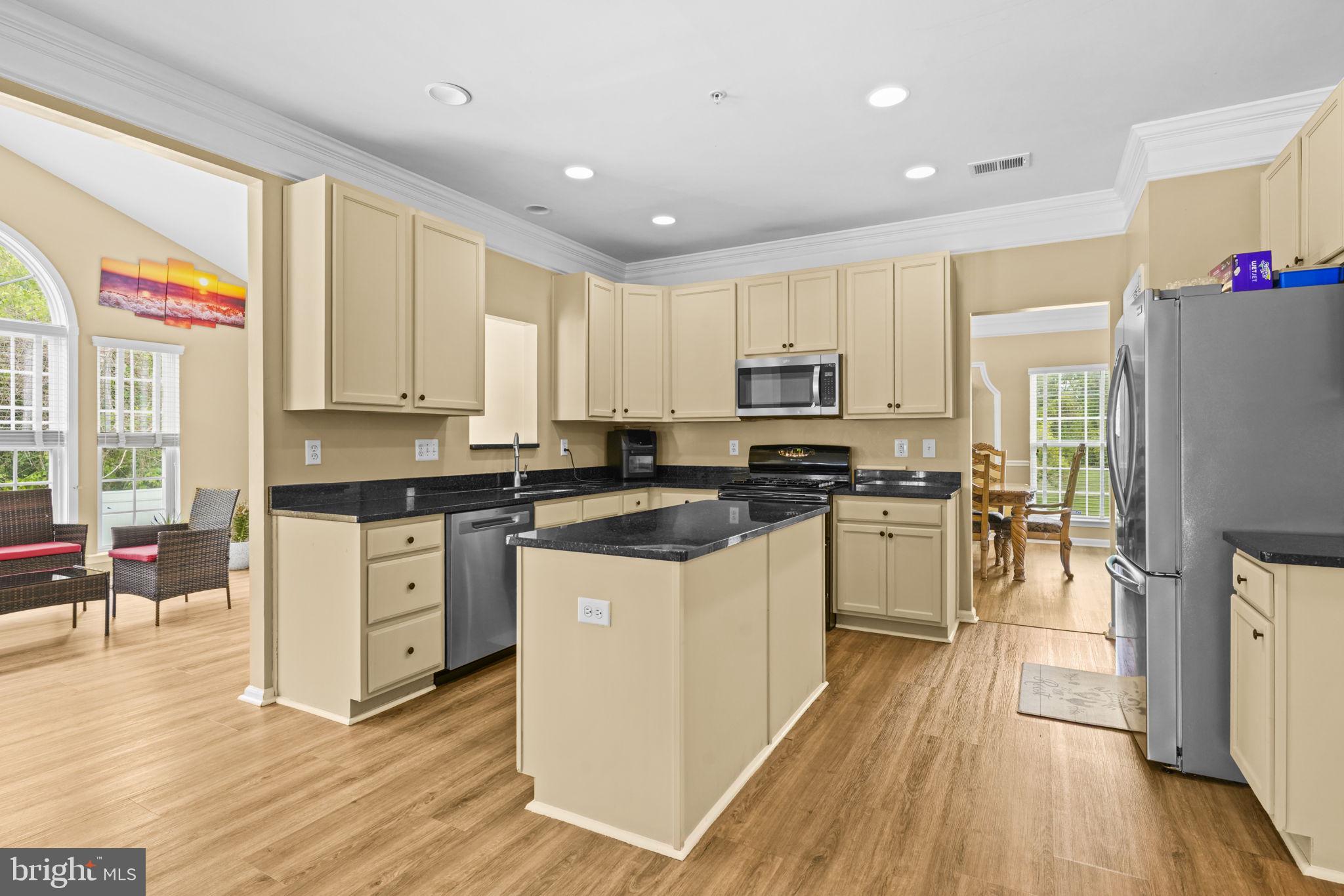 1507 St Albans Lane Accokeek, MD 20607 - Photo 14 of 36 a kitchen with stainless steel appliances granite countertop a refrigerator a stove top oven a sink and dishwasher with wooden floor