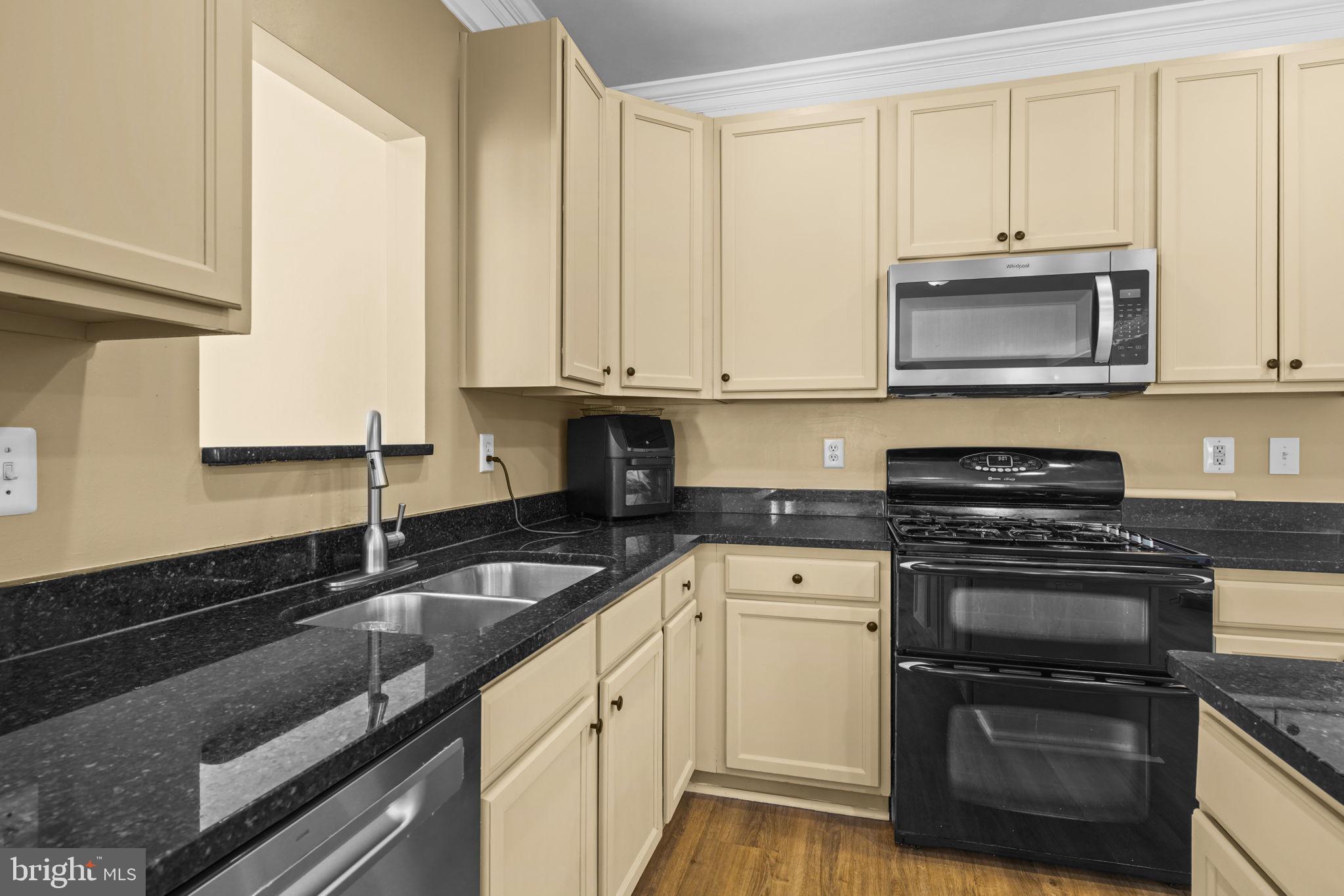 1507 St Albans Lane Accokeek, MD 20607 - Photo 17 of 36 a kitchen with granite countertop white cabinets and a stove top oven