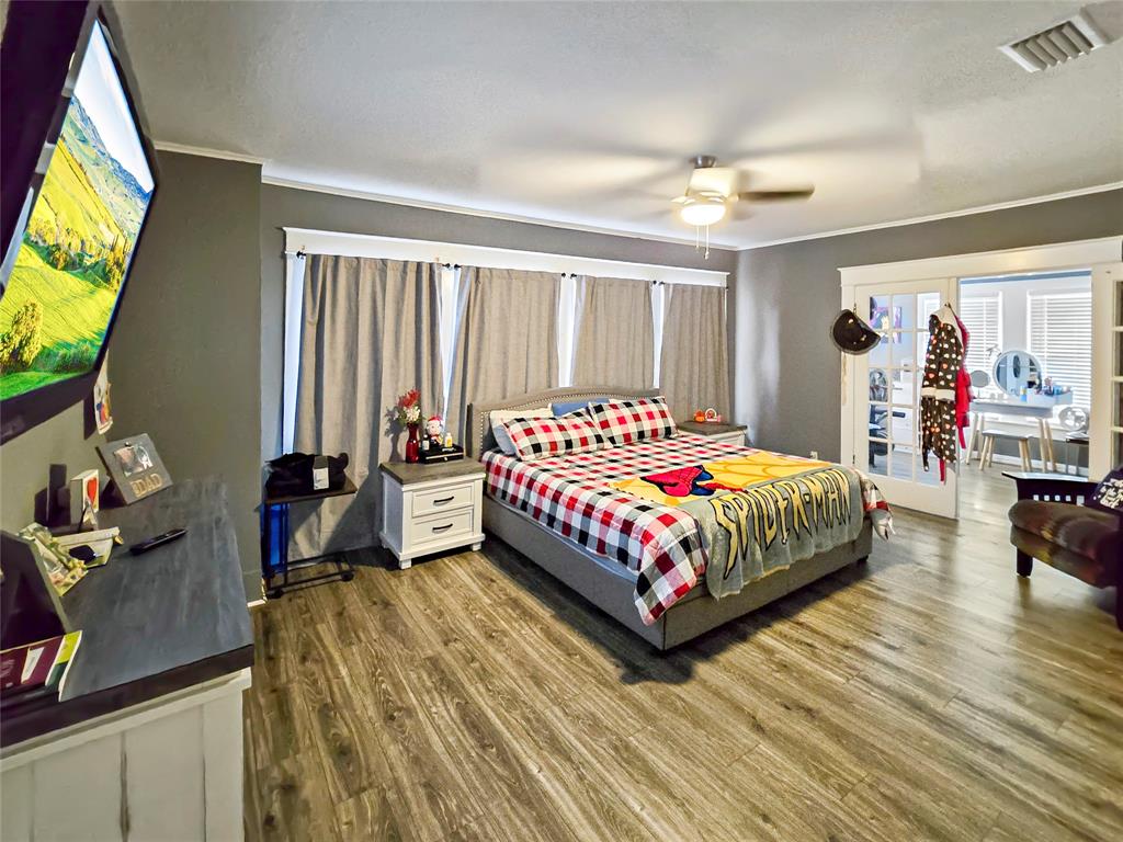 502 Griffith Avenue Terrell, TX 75160 - Photo 11 of 25 a bedroom with a bed table and a flat screen tv