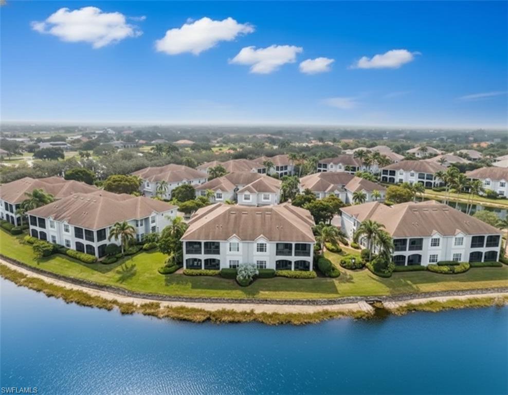 5045 Blauvelt Way, Unit 201 Naples, FL 34105 - Photo 2 of 39 an aerial view of residential houses with yard and lake view