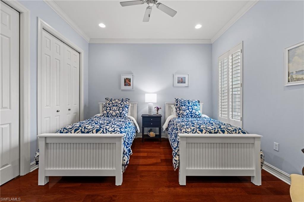 5045 Blauvelt Way, Unit 201 Naples, FL 34105 - Photo 34 of 39 a bedroom with a bed and a chandelier