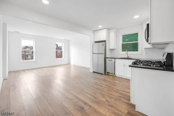 a kitchen with wooden floors and white appliances