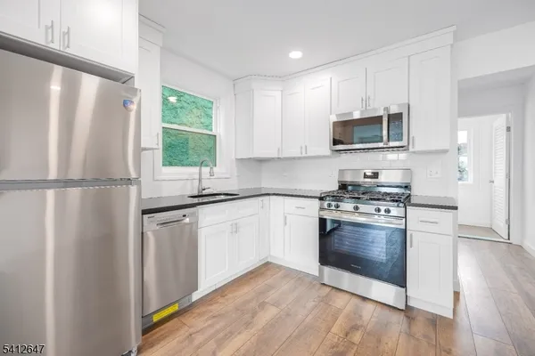 a kitchen with stainless steel appliances granite countertop a refrigerator sink and microwave