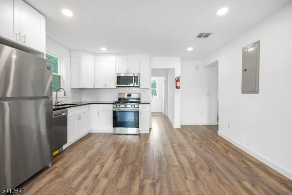a kitchen with stainless steel appliances a refrigerator sink and cabinets