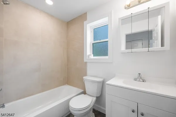 a bathroom with a toilet a sink a mirror and a bathtub