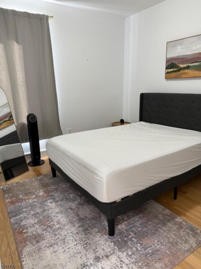 492 South 20th Street Newark, NJ 07103 - Photo 11 of 13 a bedroom with a bed and wooden floor