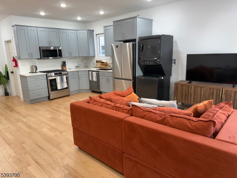 492 South 20th Street Newark, NJ 07103 - Photo 3 of 13 a kitchen with stainless steel appliances wooden floor and a refrigerator
