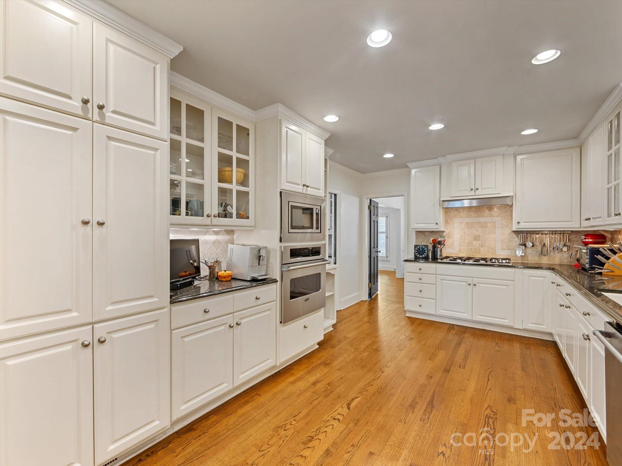4233 Columbine Circle Charlotte, NC 28211 - Photo 26 of 47 a large kitchen with stainless steel appliances granite countertop a lot of counter space and wooden floors