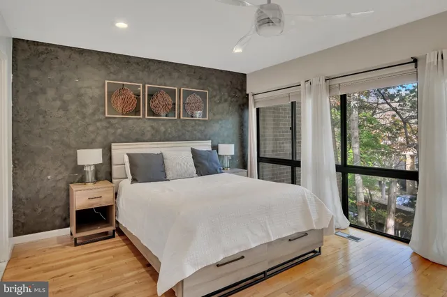 a large bedroom with a bed and wooden floor