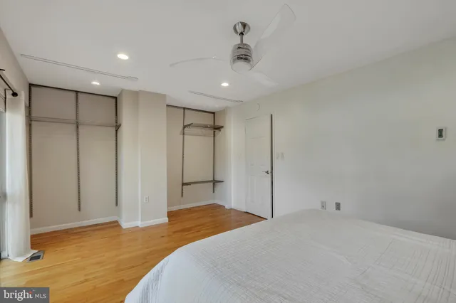 a bedroom with a bed and a ceiling fan