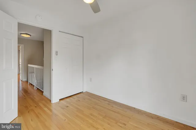 a view of an empty room with wooden floor and closet