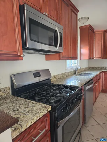 a kitchen with stainless steel appliances granite countertop a stove and a microwave