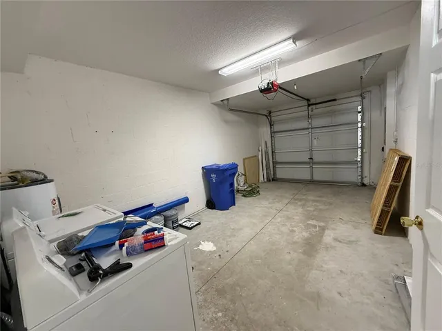 a kitchen with stainless steel appliances granite countertop a refrigerator a sink dishwasher a stove and white countertops with wooden floor