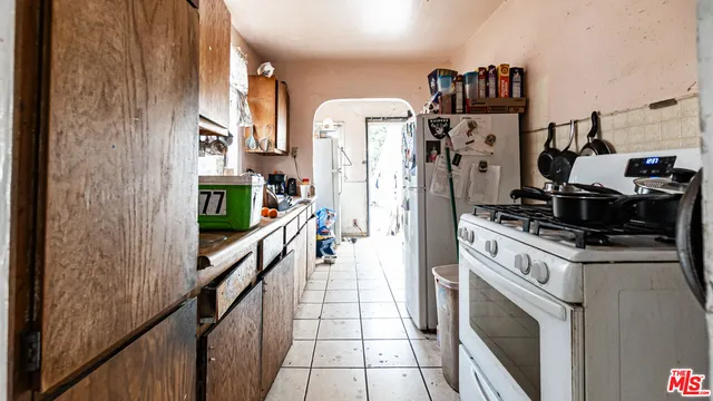 a kitchen with refrigerator a stove and a wooden floor