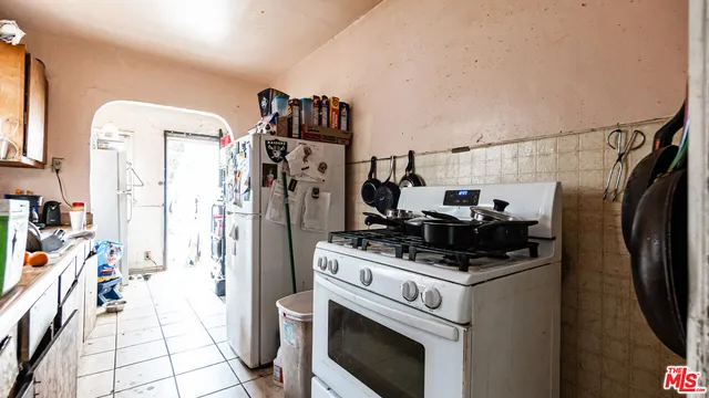 a kitchen with stainless steel appliances a stove a refrigerator and a fireplace