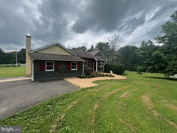 a front view of a house with yard and green space
