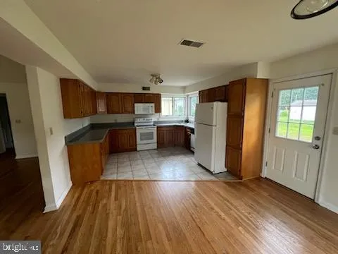 a kitchen with a wooden floor and a refrigerator