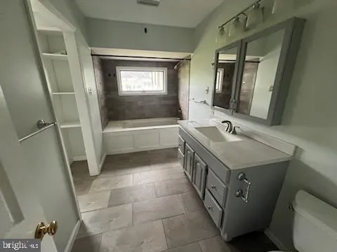 a bathroom with a tub sink and mirror