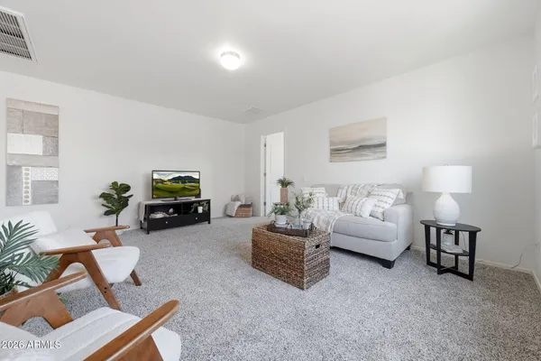 a living room with furniture flowerpot and wooden floor