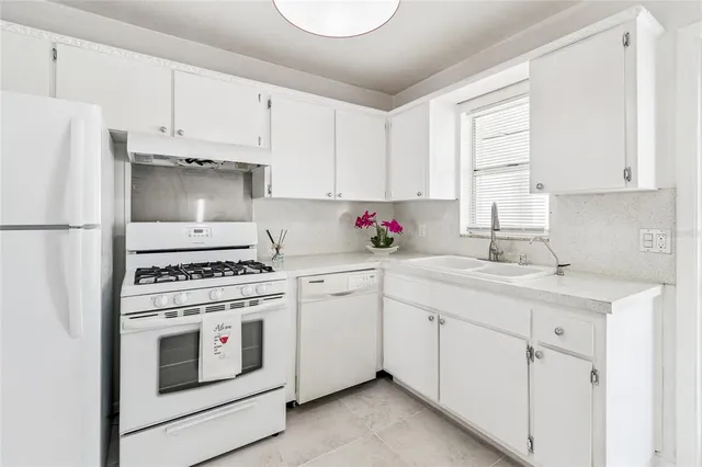 a kitchen with cabinets appliances a sink and a window