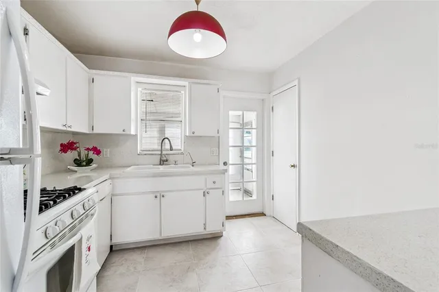 a kitchen with granite countertop a sink stainless steel appliances and cabinets